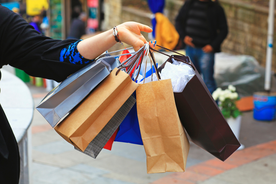 Person holding many shopping bags